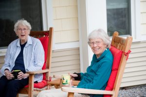Two women at Scott-Farrar sitting in chairs enjoying a conversation